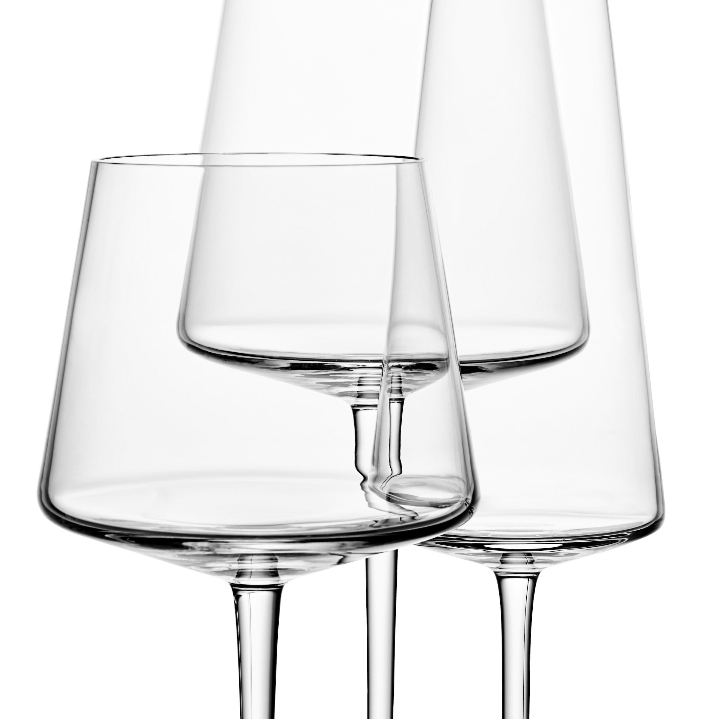 Deux verres à vin transparents de formes et de tailles différentes sont disposés avec art sur un fond blanc. Ce verre, issu de l&