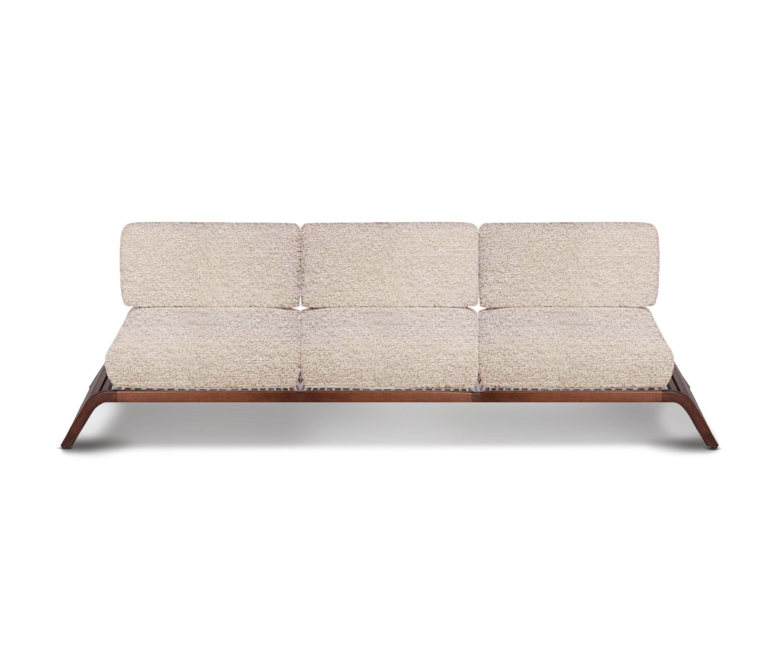 Le canapé dextérieur triple Horizon de Humble Nature présente un design moderne, des coussins beige clair fabriqués à partir de tissus de haute qualité et une structure élégante en bois foncé. Son style minimaliste comprend des pieds inclinés et un support de dossier fin, alliant élégance et confort sur un fond blanc.