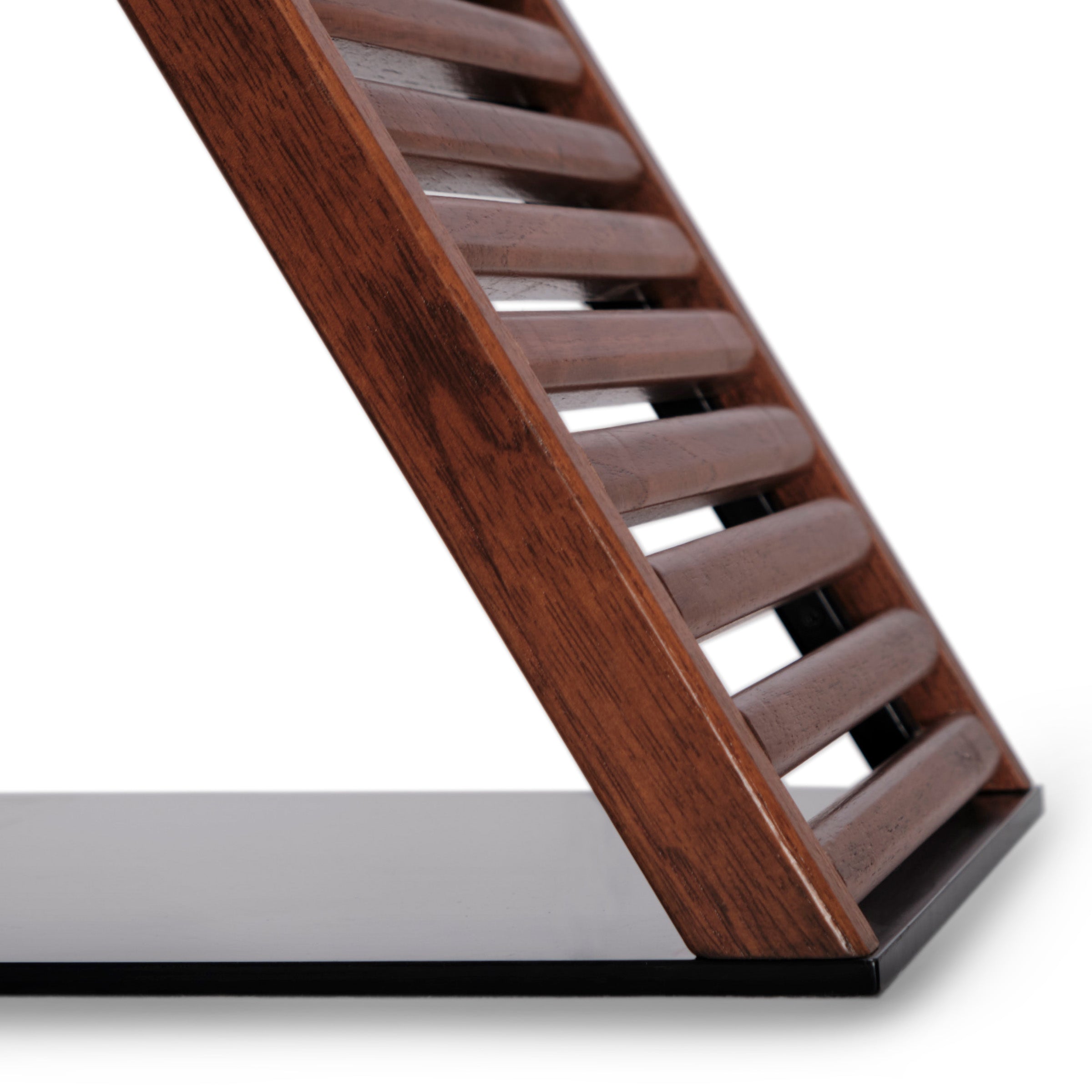 Un gros plan de la table à café Horizon de Humble Nature révèle une structure diagonale en lattes de bois fabriquées à partir de bois écoresponsable, reposant sur une surface noire lisse. La riche couleur brune et le grain du bois rehaussent la qualité supérieure du design, contrastant magnifiquement avec la base noire.