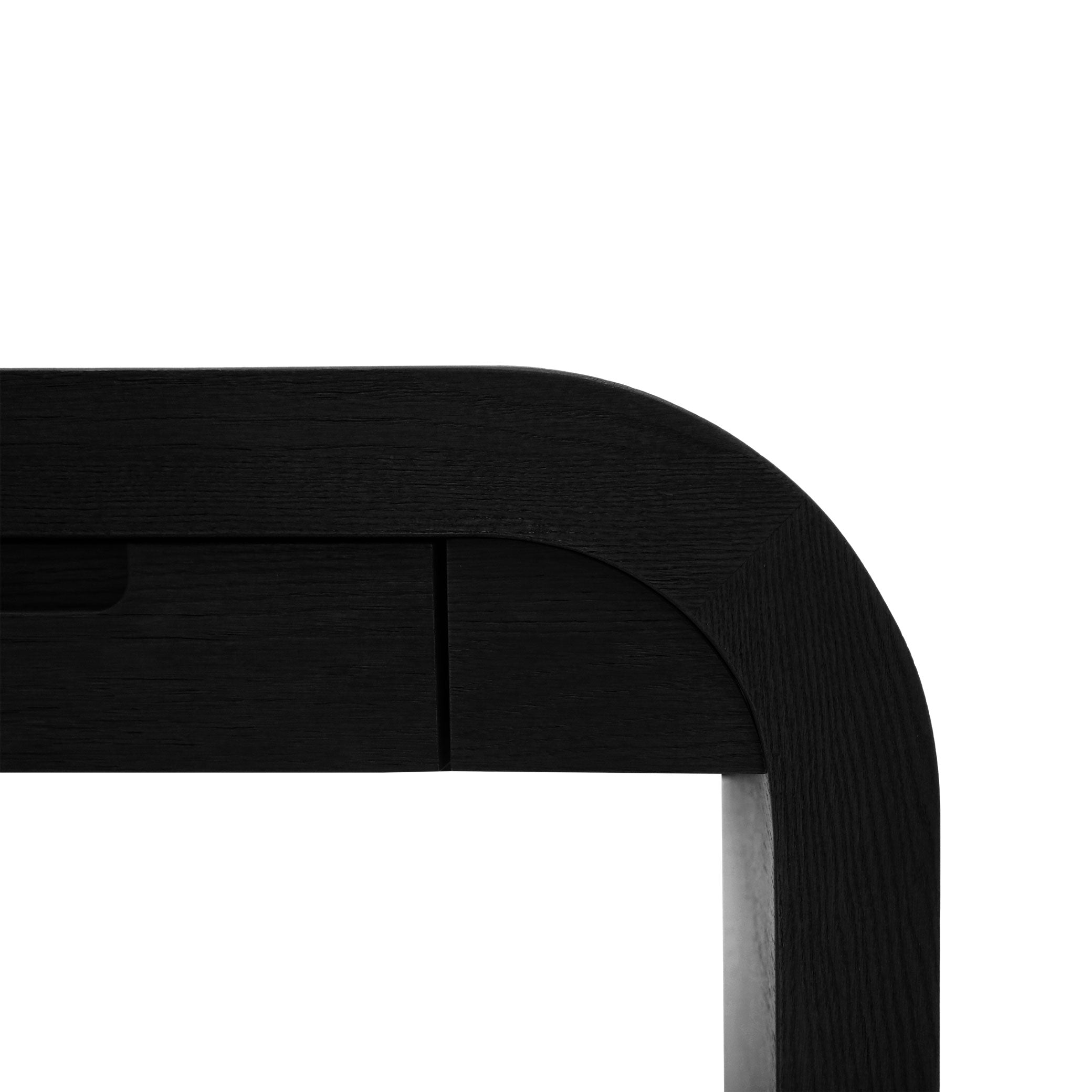 Gros plan sur la Table de travail Essence │ ONYX de Humble Nature, un élégant bureau en bois noir au design minimaliste. Ses bords lisses et ses lignes élégantes sur fond blanc en font la table idéale pour allier fonctionnalité et style dans tout espace de travail.