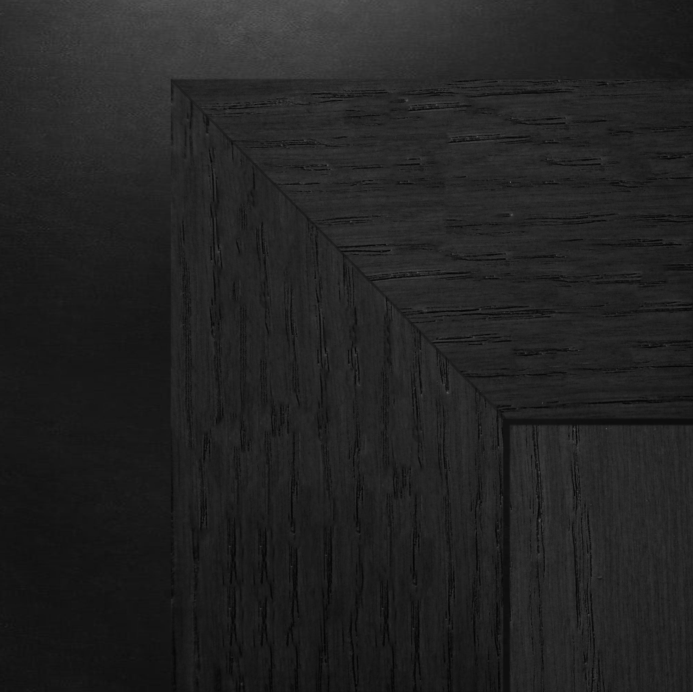 Gros plan dune surface en bois foncé et texturée formant un coin avec des motifs de grain visibles. Léclairage met en valeur les lignes et les bords naturels du bois, rappelant See & Pure - Ensemble de moulures Passage │ ONYX de Humble Nature, avec une teinte sombre lisse et similaire en arrière-plan.