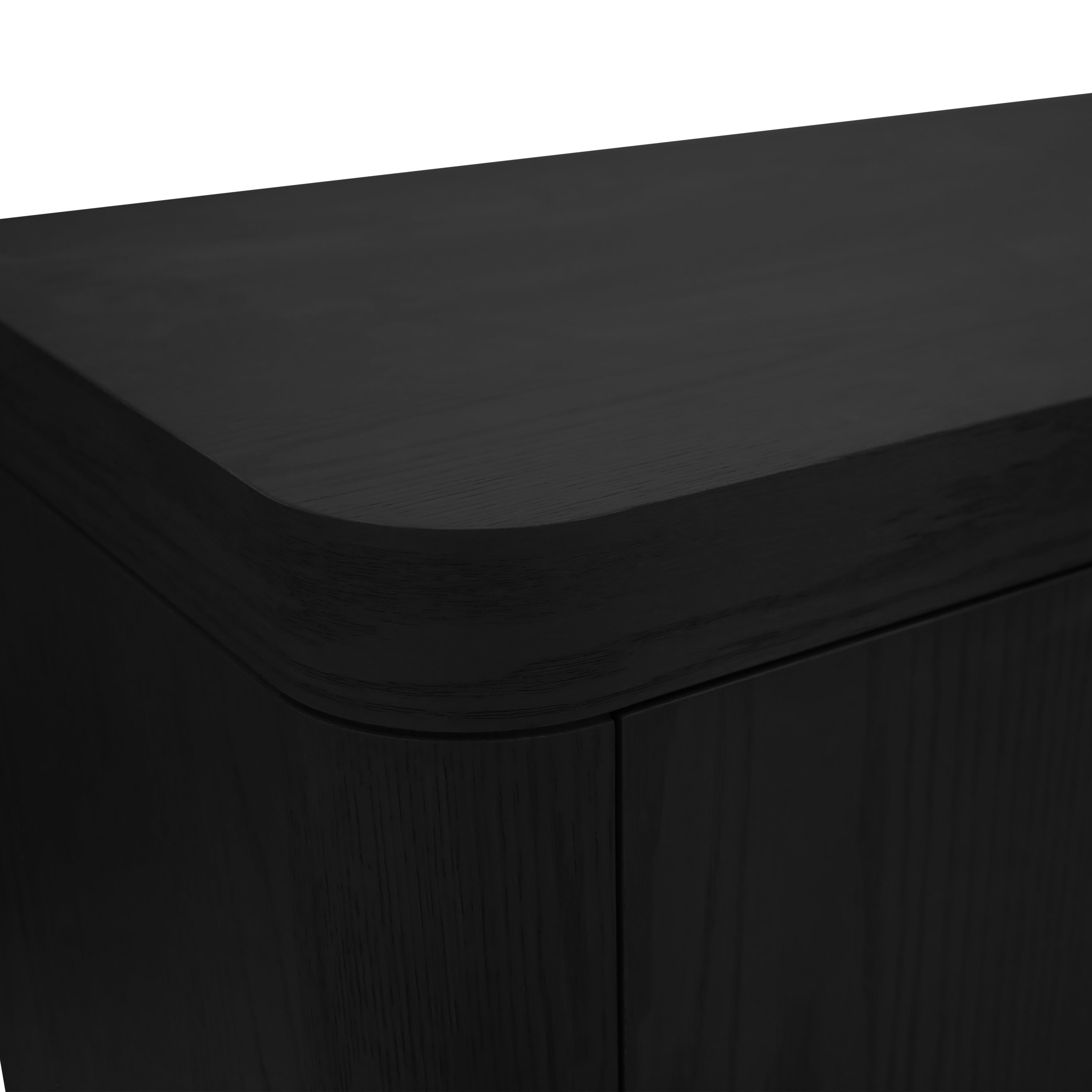 Gros plan de la console darmoire Origin | ONYX par Humble Nature. Cette armoire en bois noir présente un coin lisse et incurvé avec une finition mate qui met en valeur sa texture subtile de grain de bois, incarnant le design authentique que lon retrouve dans les armoires et commodes de haute qualité.