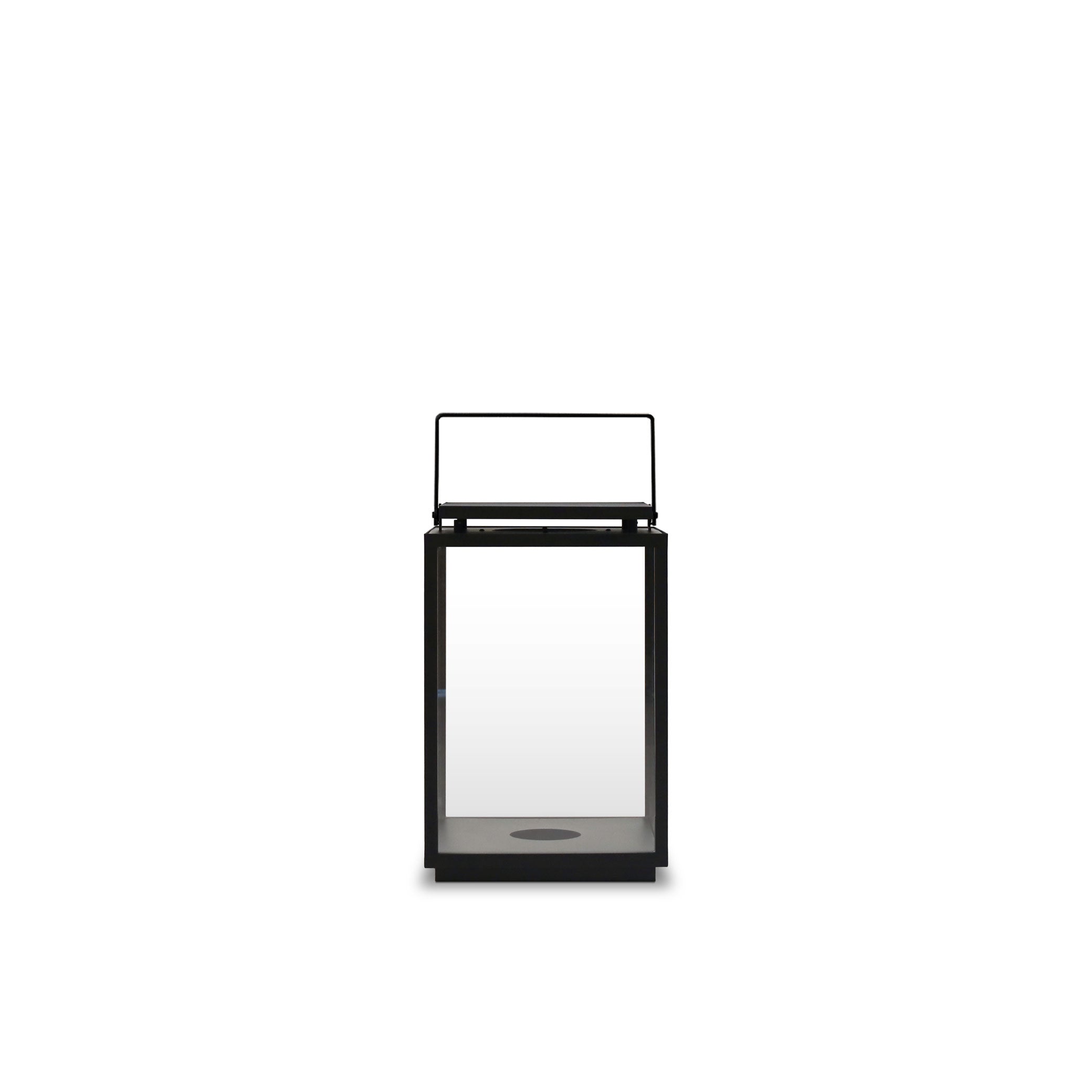 La Lanterne extérieure & intérieure │ LARGE de Humble Nature est une lanterne minimaliste en aluminium à cadre noir avec un boîtier en verre rectangulaire et une poignée supérieure simple, sur un fond blanc uni.
