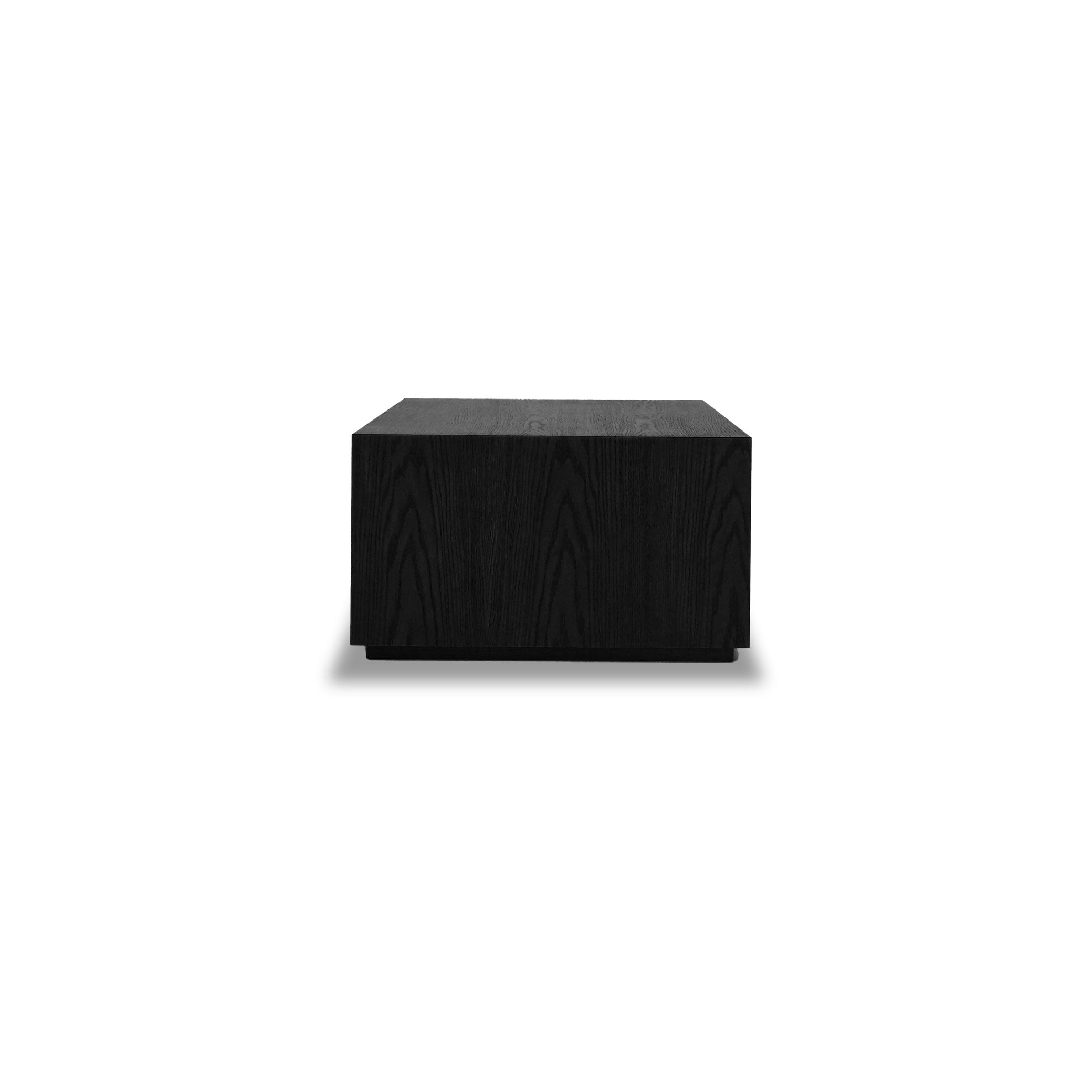Une table basse rectangulaire noire et minimaliste nommée « Table basse rectangulaire 36 Essence | Onyx » par Humble Nature, présentant des surfaces lisses et une texture de grain de bois subtile rappelant les matériaux naturels, présentée sur un fond blanc uni.