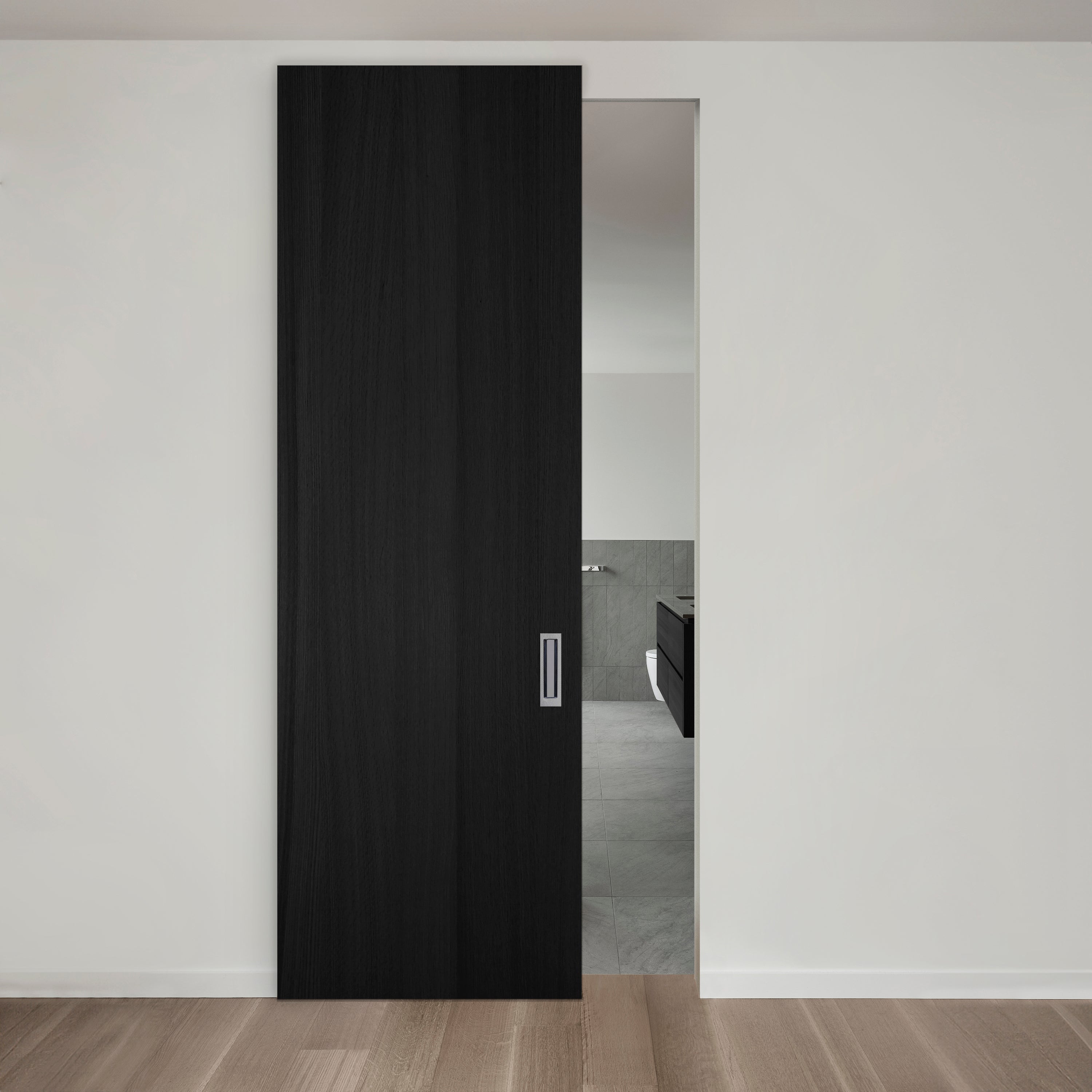 Une porte coulissante noire moderne est partiellement ouverte, révélant un aperçu d'un intérieur minimaliste avec des murs gris clair et du parquet en bois.