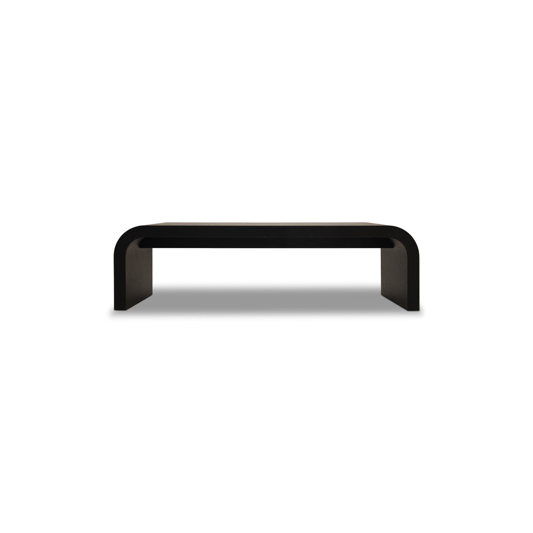 Le Banc 64 en bois Essence │ ONYX de Humble Nature est une banc noir minimaliste avec une surface rectangulaire lisse et des bords élégamment incurvés, reflétant la sophistication alors quelle se dresse gracieusement sur un fond gris clair.