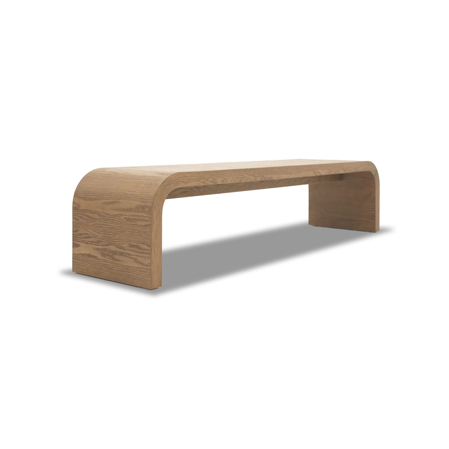 Le Banc 80 en bois Essence de Humble Nature est un banc en bois minimaliste au design lisse et incurvé fabriqué en bois de chêne rouge. Il présente une finition naturelle claire, un plateau en surplomb, des côtés ouverts et repose sur une surface plane, projetant une ombre douce qui met en valeur sa simplicité esthétique.