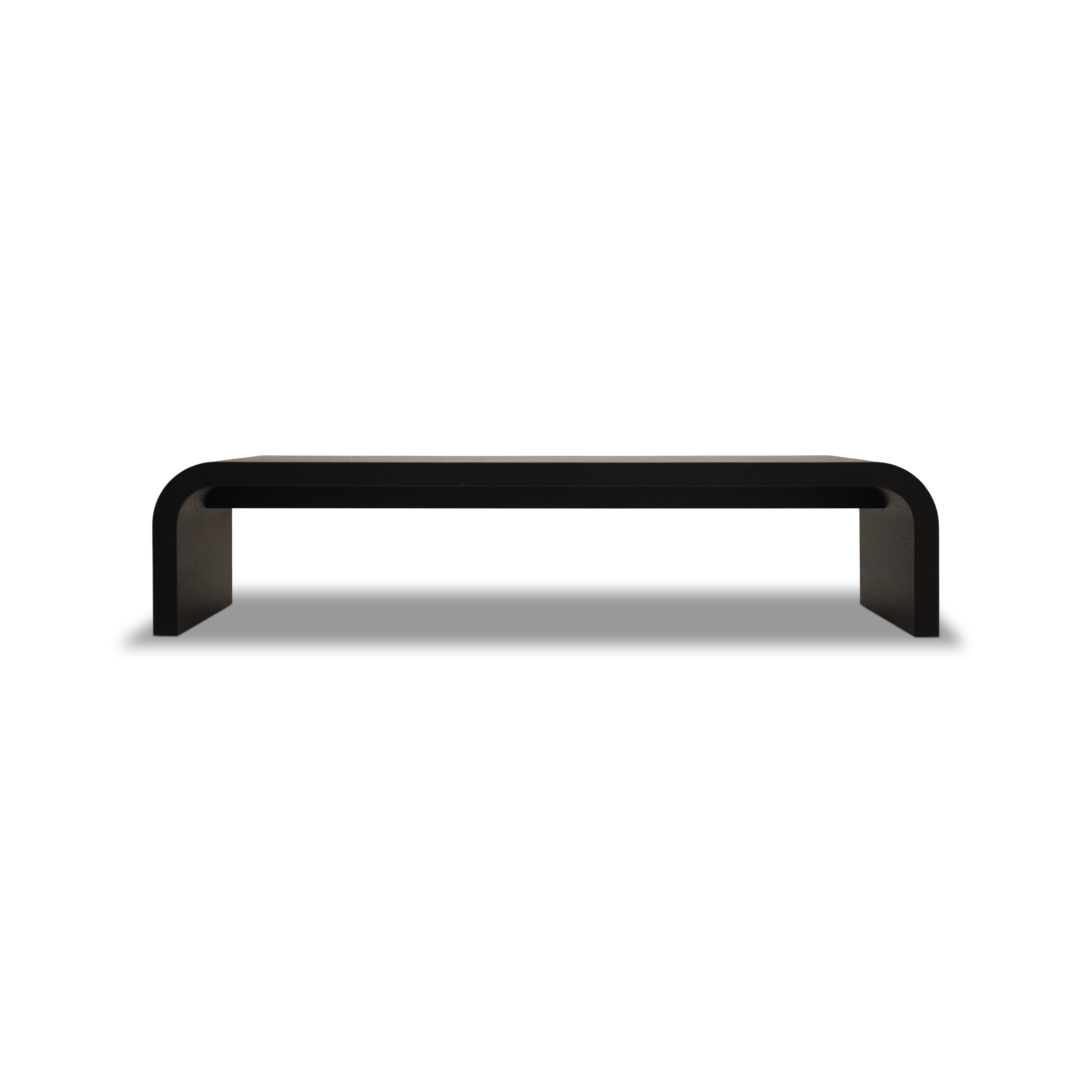 Le Banc 80 en bois Essence │ ONYX de Humble Nature présente un banc noir minimaliste au design lisse et incurvé. Fabriqué en chêne rouge massif, ses bords arrondis rehaussent lesthétique épurée et moderne sur un fond blanc uni.