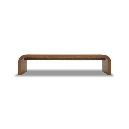 Le Banc 80 en bois Essence de Humble Nature, fabriqué en bois massif de chêne rouge, présente un design minimaliste avec une finition lisse et des bords incurvés sur un fond blanc uni.