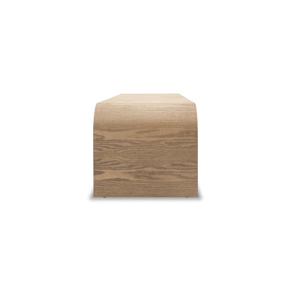 Le Banc 64 en bois Essence │ AUTHENTIK de Humble Nature est une pièce rectangulaire en bois de chêne rouge au fini lisse et naturel. Son motif de grain visible complète le design minimaliste et moderne, créant un look exquis en bois massif qui semble légèrement surélevé.