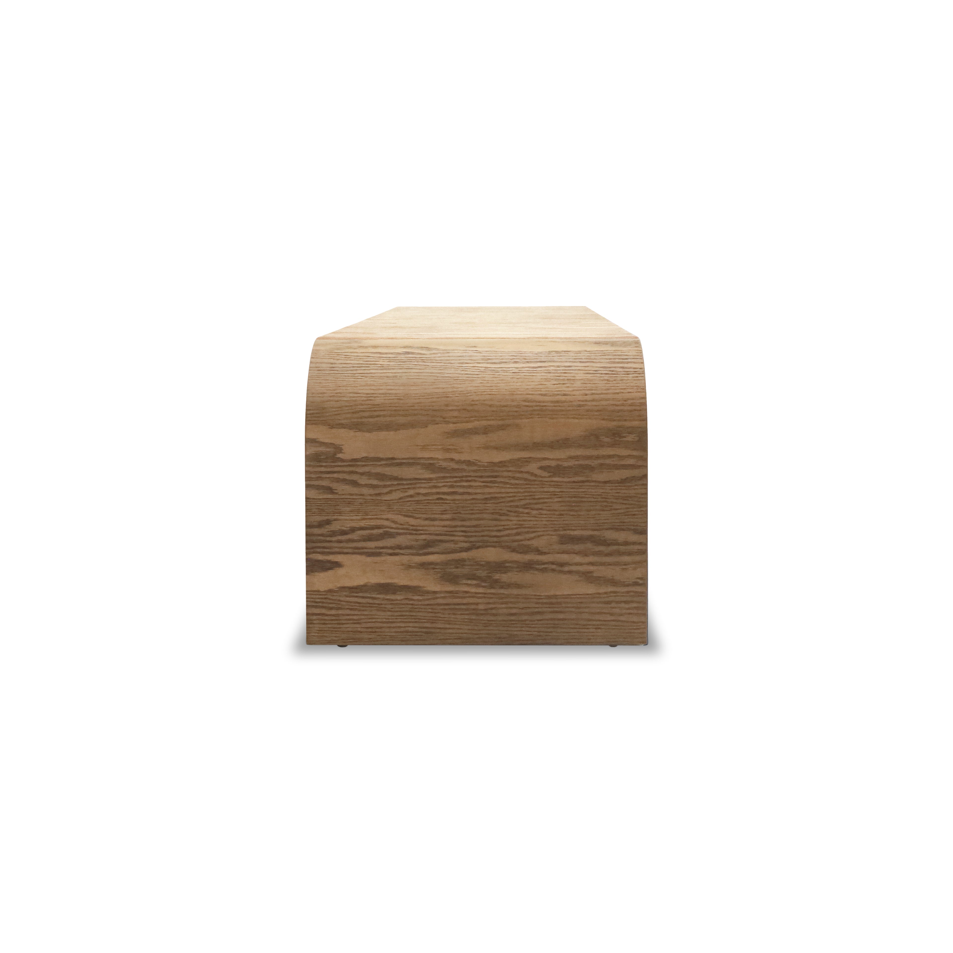 Vue de face du Banc 64 en bois Essence │ SADDLE de Humble Nature, doté dune esthétique épurée et dun design lisse et courbé. Fabriqué en bois massif, il présente une élégante finition en grain de bois sur un fond blanc uni.