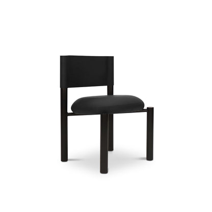 La chaise de salle à dîner en cuir Barrel | ONYX de Humble Nature est une chaise de salle à manger noire et minimaliste avec un dossier rectangulaire et un siège en cuir rembourré, soutenu par quatre pieds cylindriques, sur un fond blanc uni.