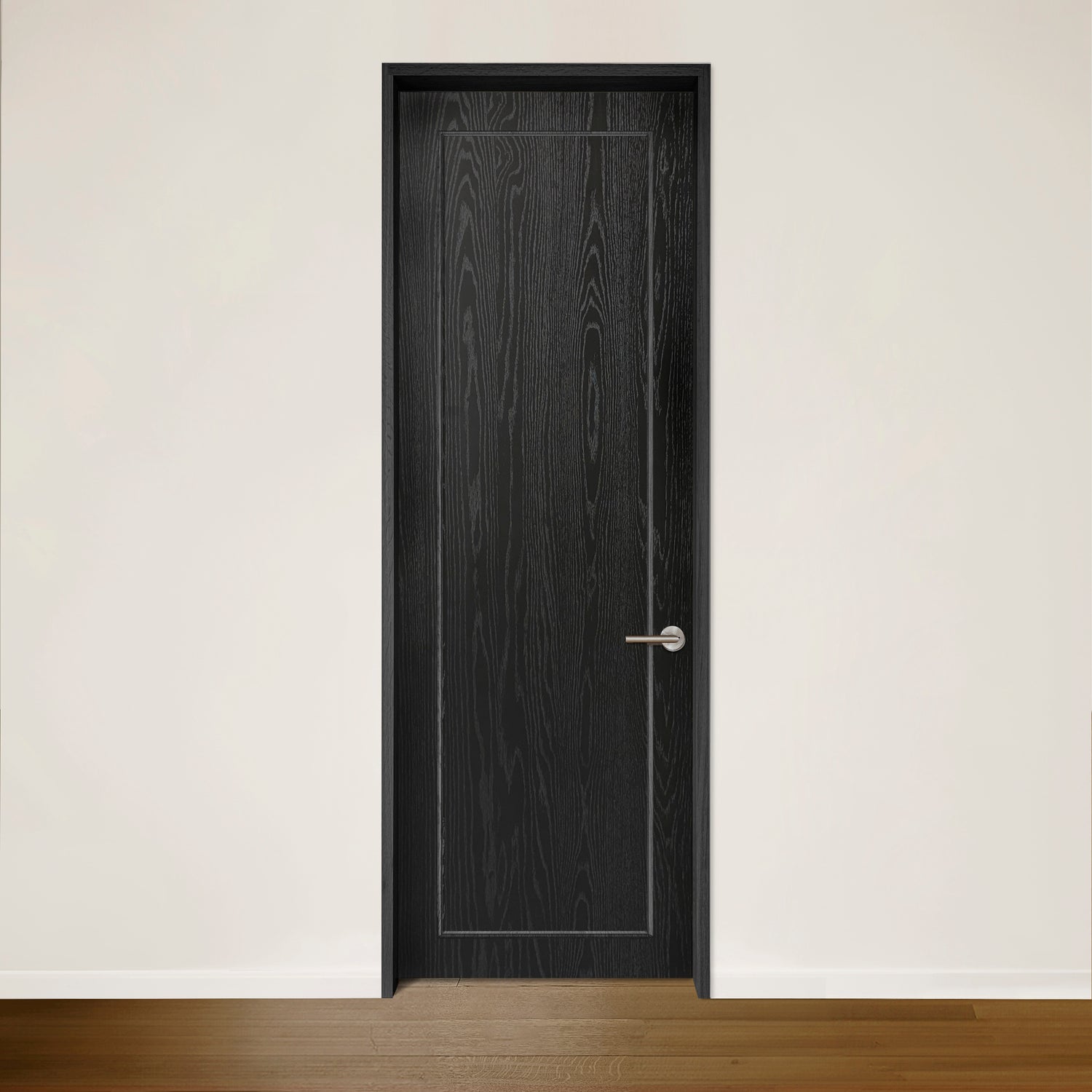 La Porte CONTOUR en placage de chêne noir Onyx de Humble Nature, avec sa poignée argentée sur un mur blanc uni, respire lélégance intemporelle. Le plancher en bois franc fabriqué à partir de bois recyclé ajoute de la chaleur au design minimaliste tout en célébrant le style écologique.