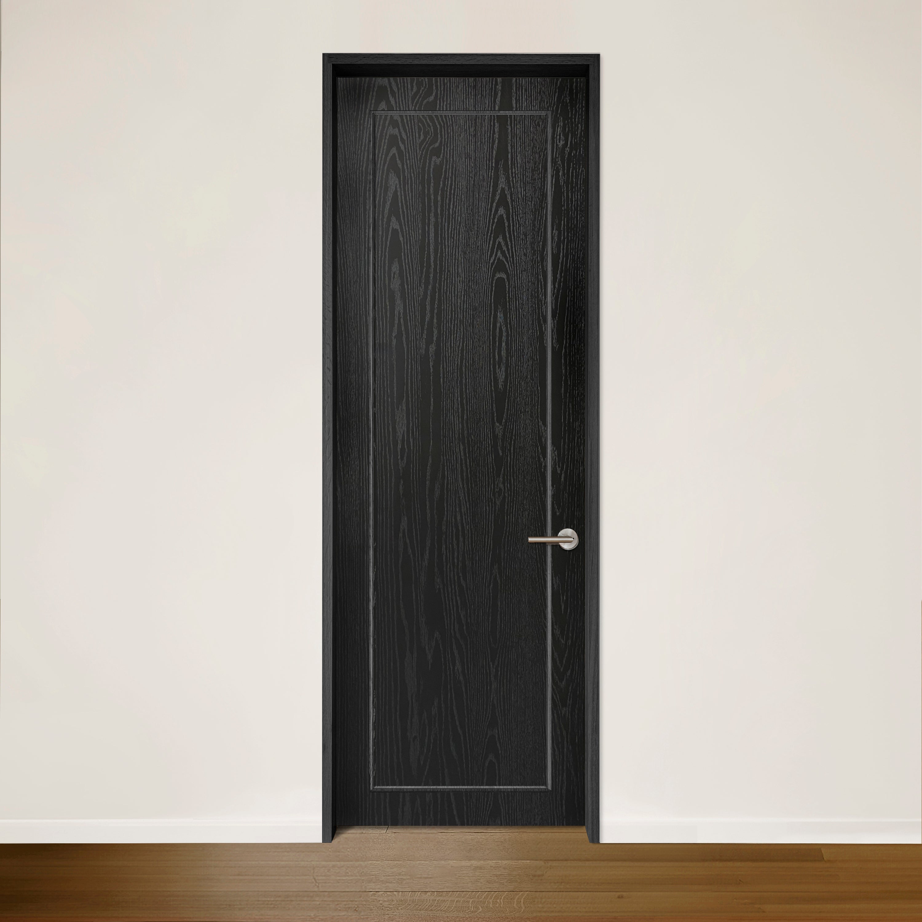 La Porte CONTOUR en placage de chêne noir Onyx de Humble Nature, avec sa poignée argentée sur un mur blanc uni, respire lélégance intemporelle. Le plancher en bois franc fabriqué à partir de bois recyclé ajoute de la chaleur au design minimaliste tout en célébrant le style écologique.