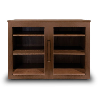 La console Humble Nature Cabinet fini pecan | porte verre est une élégante armoire en bois avec une finition marron foncé et deux portes à panneaux en verre. Elle comporte quatre étagères intérieures et une poignée centrale verticale, joliment présentées sur un fond blanc.