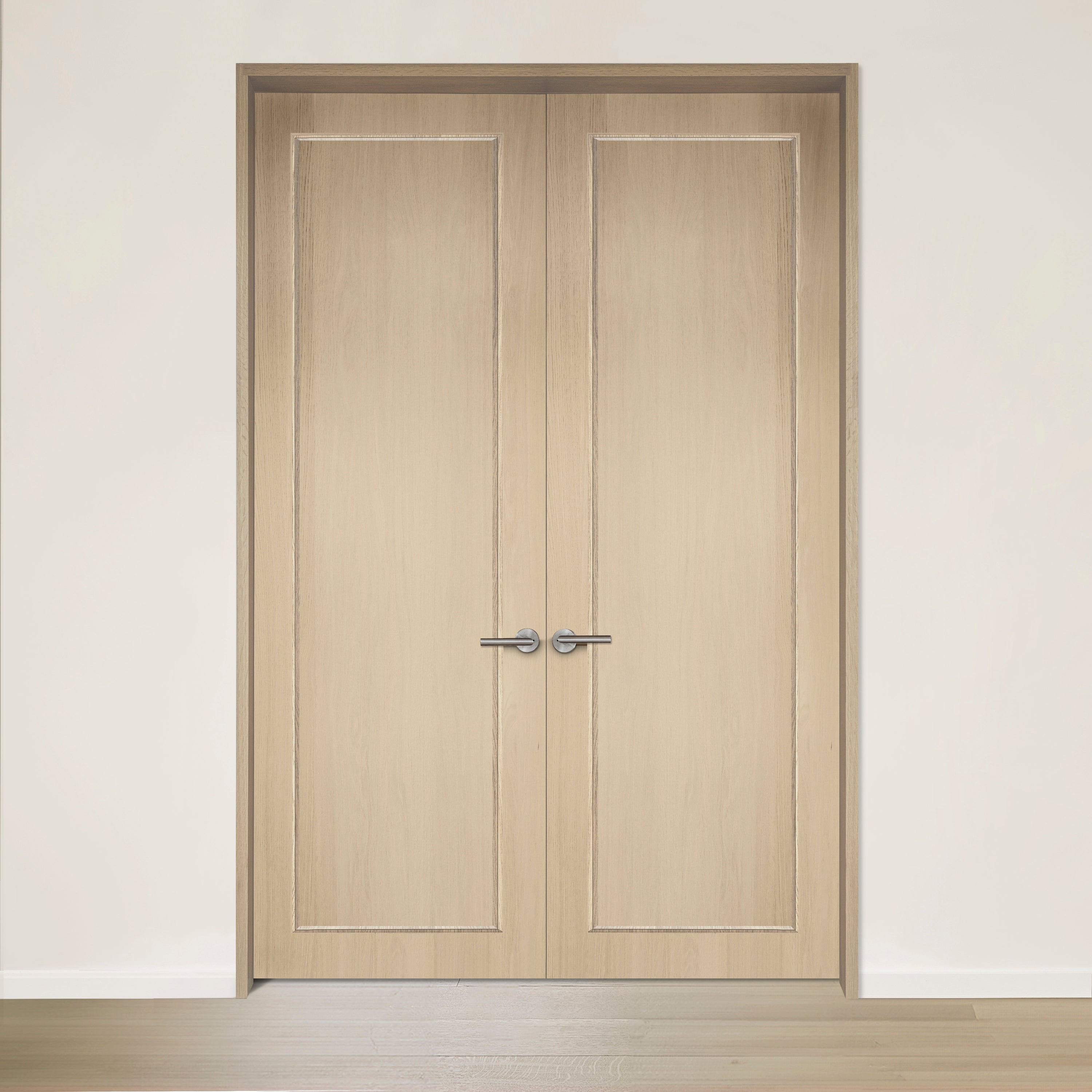 La porte double CONTOUR en chêne blanc placage brossé sur dosse de Humble Nature présente une construction en bois clair avec des poignées argentées élégantes, située dans un mur neutre et un plancher en bois clair. Fabriqué au Québec, son design dégage une élégance intemporelle.