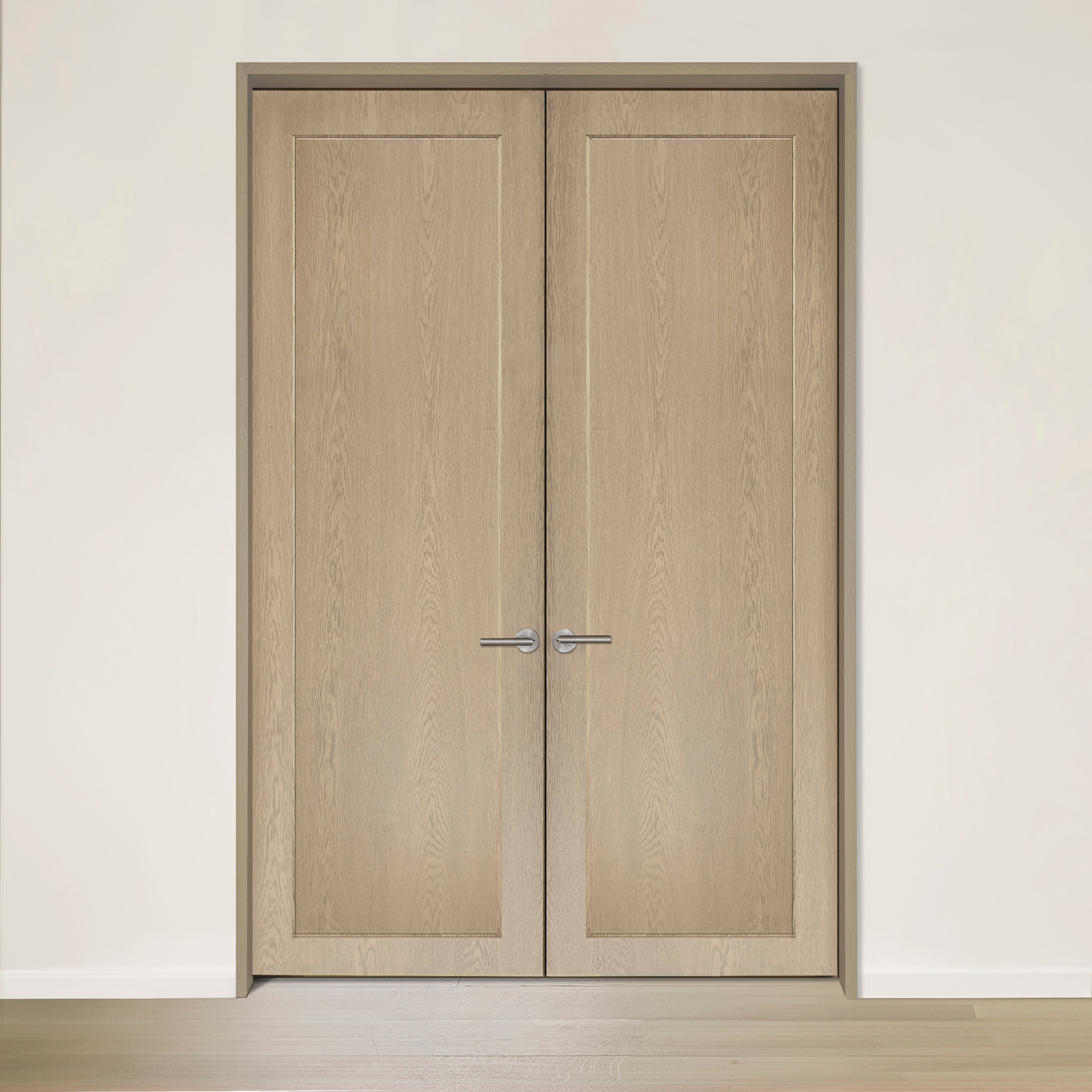 La Porte double CONTOUR de Humble Nature, réalisée en placage de chêne rouge, présente des panneaux simples et des poignées métalliques épurées, mêlant une élégance intemporelle à un mur blanc avec un parquet en bois clair.