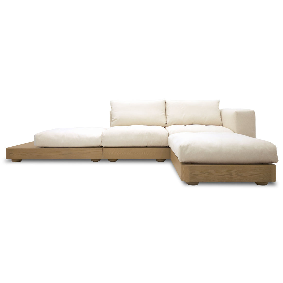 Le canapé simple Essence | Authentik de Humble Nature, un canapé sectionnel moderne en L avec une base basse en bois et des coussins blancs, capture lessence de lartisanat nord-américain. Son design minimaliste sur fond blanc uni allie harmonieusement élégance et confort luxueux.