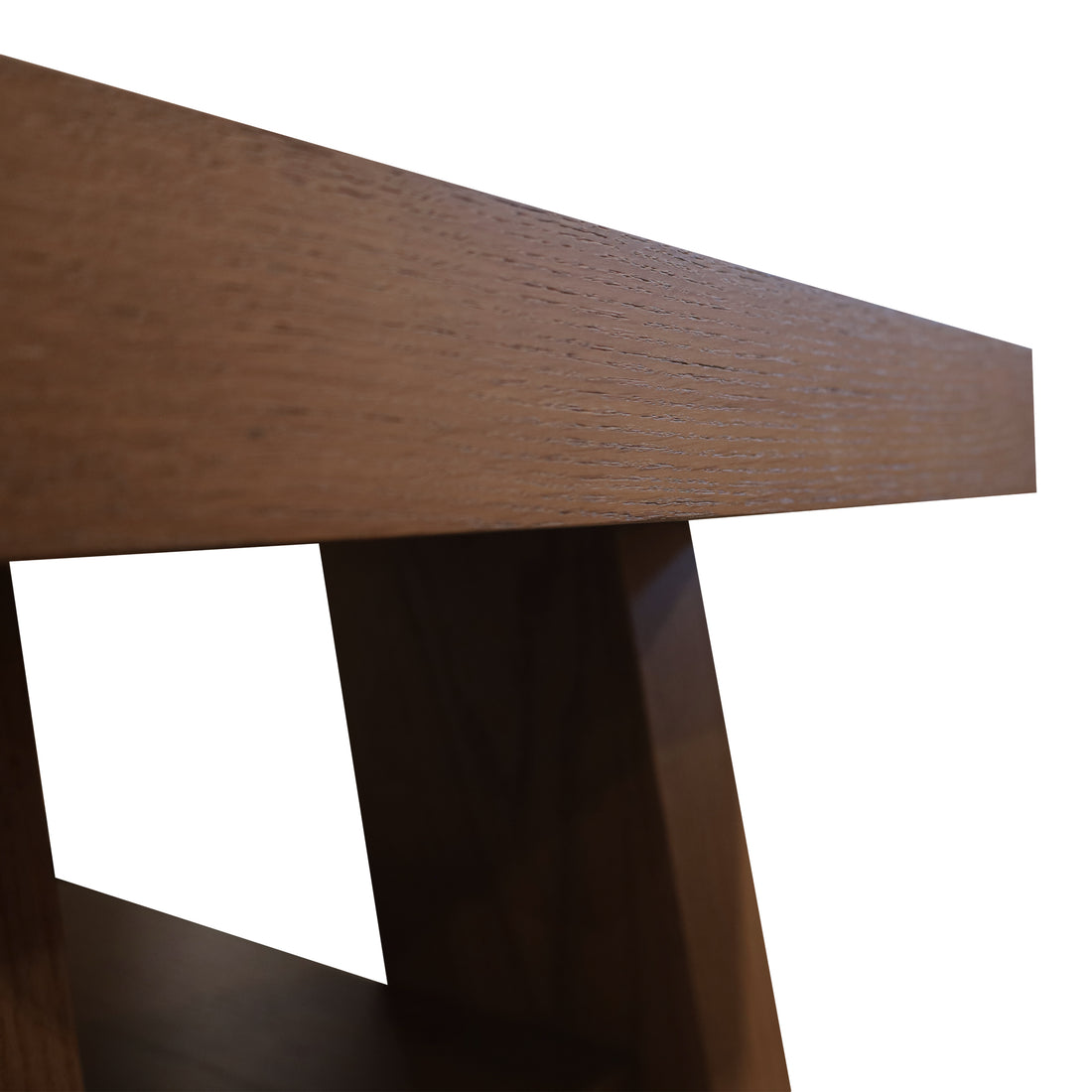 Un gros plan de la console de table Origin | SADDLE de Humble Nature révèle sa surface en bois lisse et ses pieds angulaires modernes sur un fond uni, mettant en valeur son design élégant et sa texture de grain, témoignage dun savoir-faire exceptionnel dans la fabrication de tables dappoint.