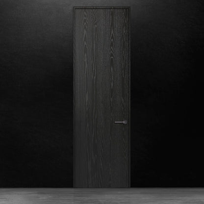 Une porte battante en bois noir en chêne rouge placage brossé sur dosse Pecan de Humble Nature se dresse contre un mur noir. Le sol est uniformément éclairé, créant une surface réfléchissante. Le motif du grain du bois ajoute une texture subtile à son design minimaliste, alliant élégance classique et touches de modernisme.