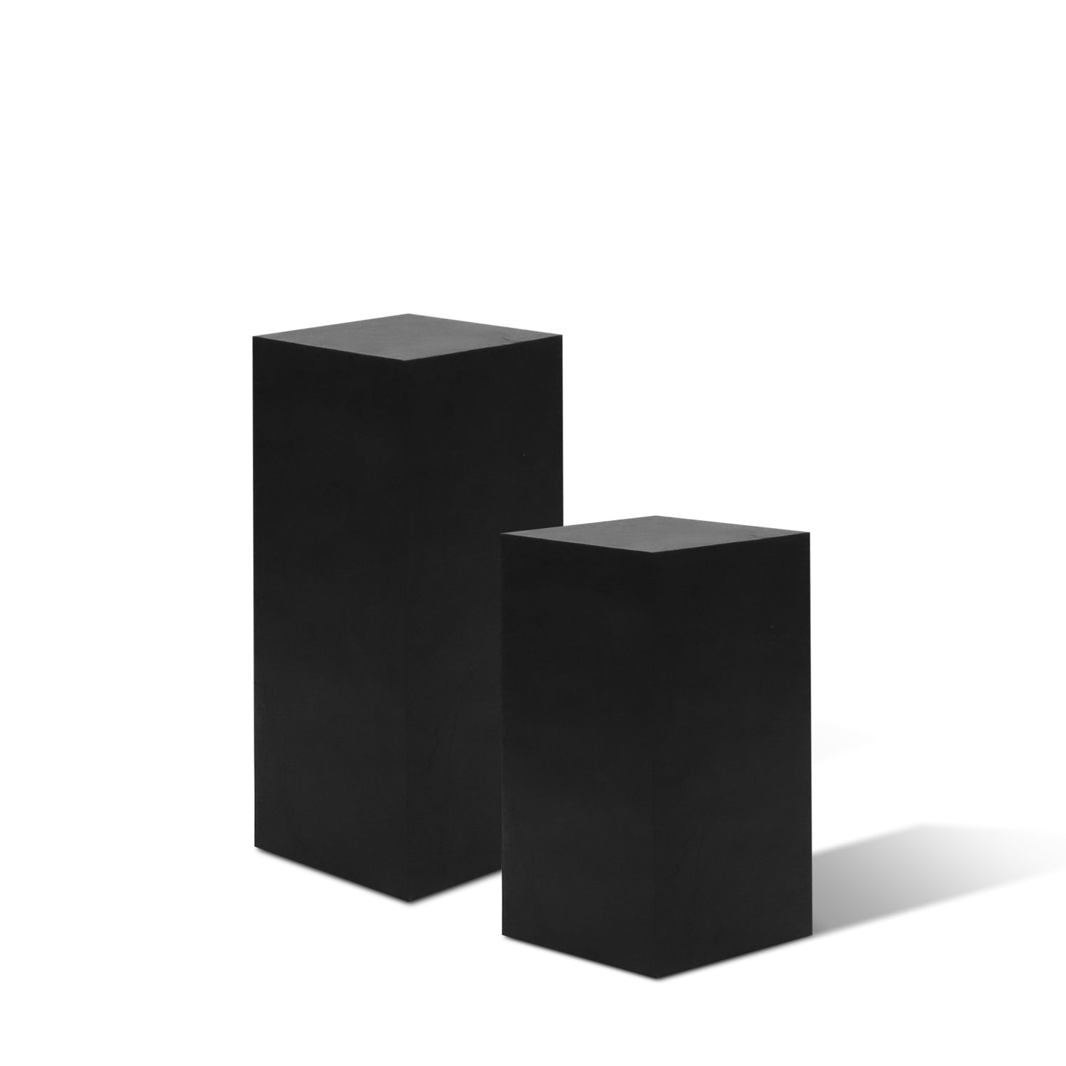 Deux ENSEMBLE DE TABLES PIÉDESTALES EN BOIS FINI PIERRE NATURELLE | ONYX rectangulaires noirs de Humble Nature se dressent sur un fond blanc, leur finition mate et lisse contrastant fortement avec lenvironnement lumineux et projetant des ombres minimales vers la droite.