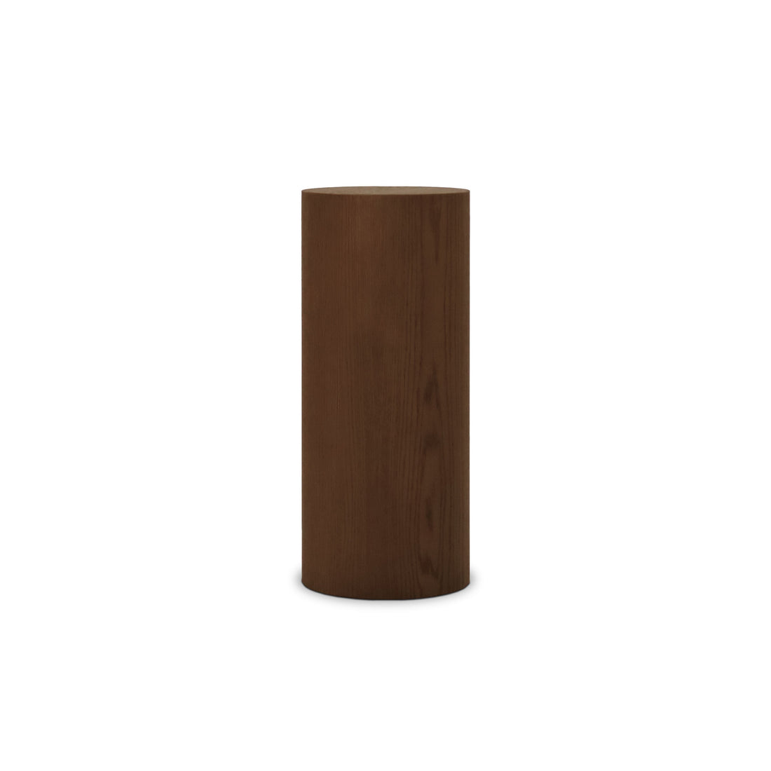 La Table piédestal circulaire 28 Essence en Pecan de Humble Nature est un piédestal en bois cylindrique vertical avec une surface lisse et une riche couleur marron, sur fond blanc uni.