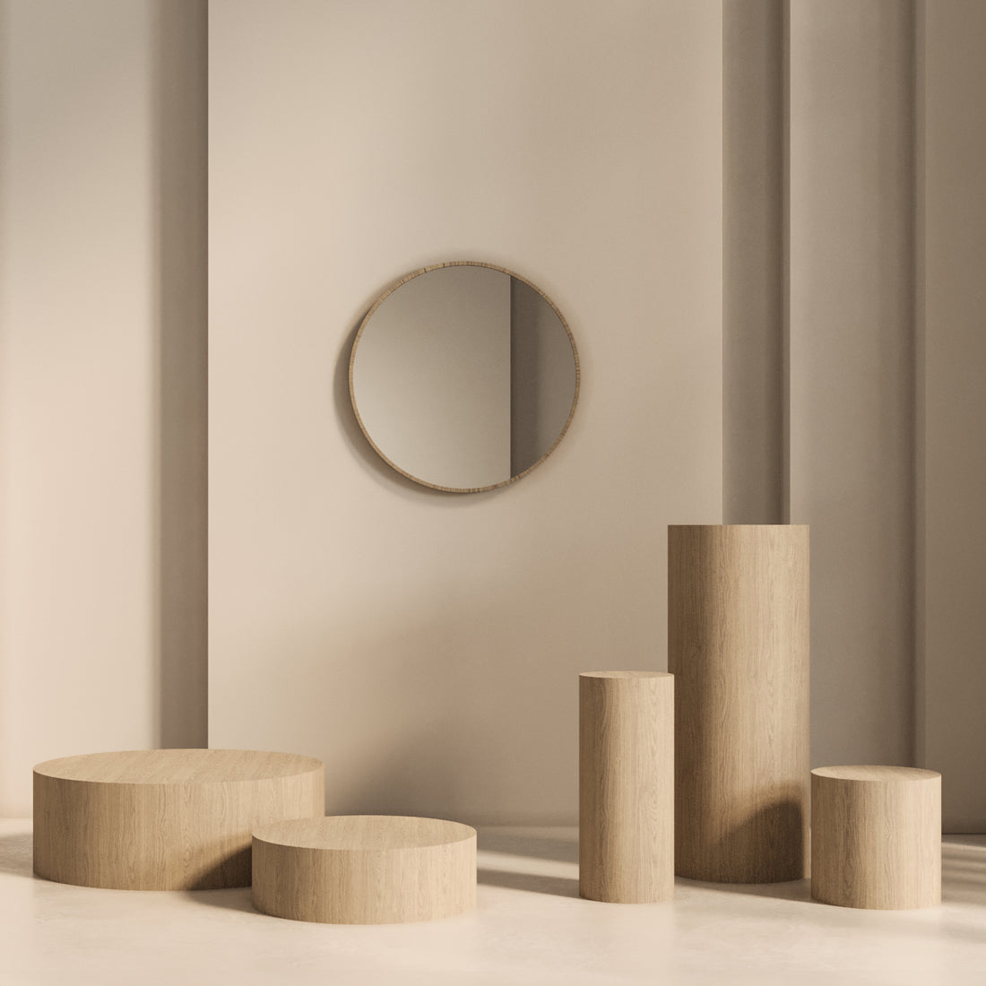 Une pièce minimaliste aux murs et au sol beiges, avec un miroir rond reflétant la lumière naturelle. La table piédestal circulaire Humble Nature 47 Essence et ses différentes plateformes en bois ajoutent une touche de modernité et de simplicité qui met en valeur la beauté des matériaux naturels.