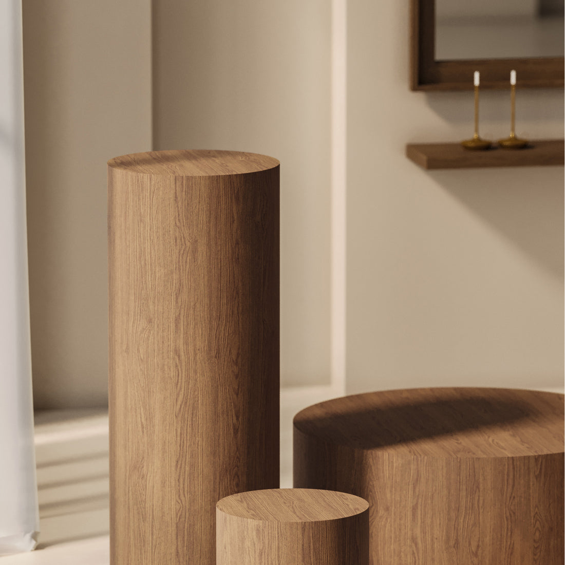 Une pièce composée de trois socles cylindriques en bois Humble Nature, de hauteurs différentes, aux touches de matériaux naturels. La décoration minimaliste comprend une grande fenêtre ornée d&