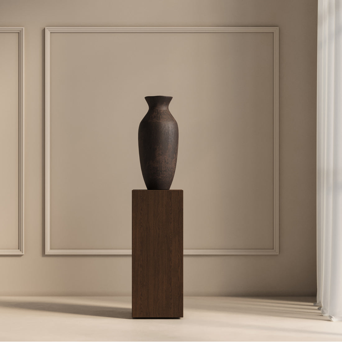 Un vase en céramique sombre trône gracieusement sur le piédestal carré 41 Essence de Humble Nature, couleur Pécan, contre un mur beige à panneaux carrés. Un éclairage tamisé crée des ombres douces, mettant en valeur les matériaux naturels, évoquant des espaces chaleureux et soignés.