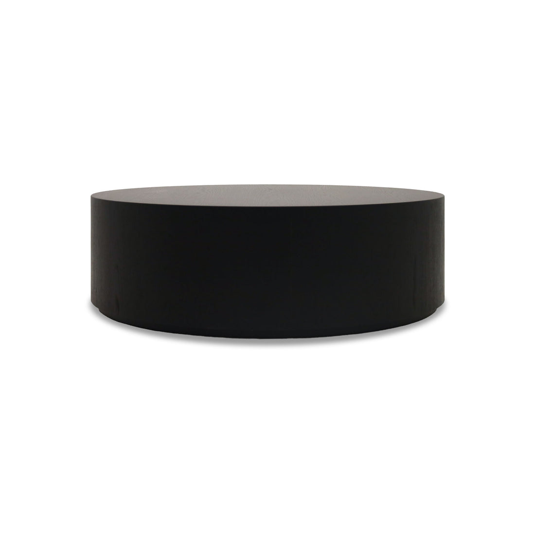 La Table basse circulaire 40 Essence | Onyx de Humble Nature est un cylindre noir solide avec un dessus plat et une surface lisse, ressemblant à des tables dappoint épurées, isolées sur un fond blanc.