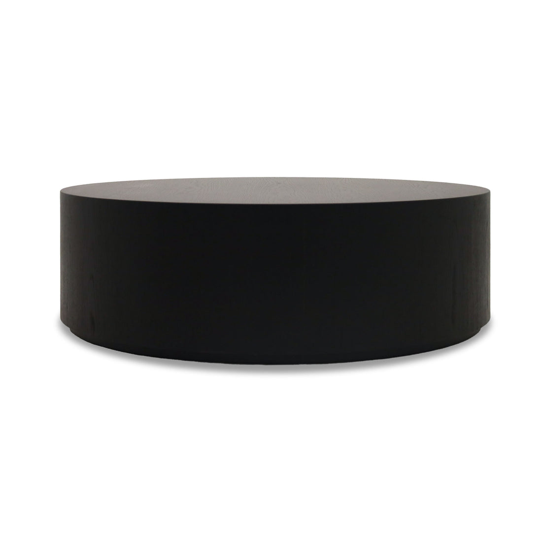 La Table basse circulaire 48 Essence | Onyx de Humble Nature, présente une forme sculpturale noire parfaite pour exposer des produits. Son design cylindrique élégant se détache sur un fond blanc, créant un contraste saisissant.