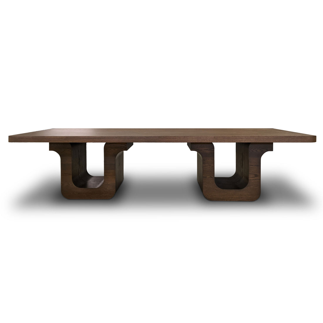 Cette Table à dîner 120 Suite │ PECAN, fabriquée par Humble Nature, présente une finition polie foncée et un grand plateau rectangulaire soutenu par deux pieds en U, ce qui en fait une superbe pièce maîtresse. Sur fond blanc, elle dégage une élégance raffinée semblable au placage de chêne rouge.