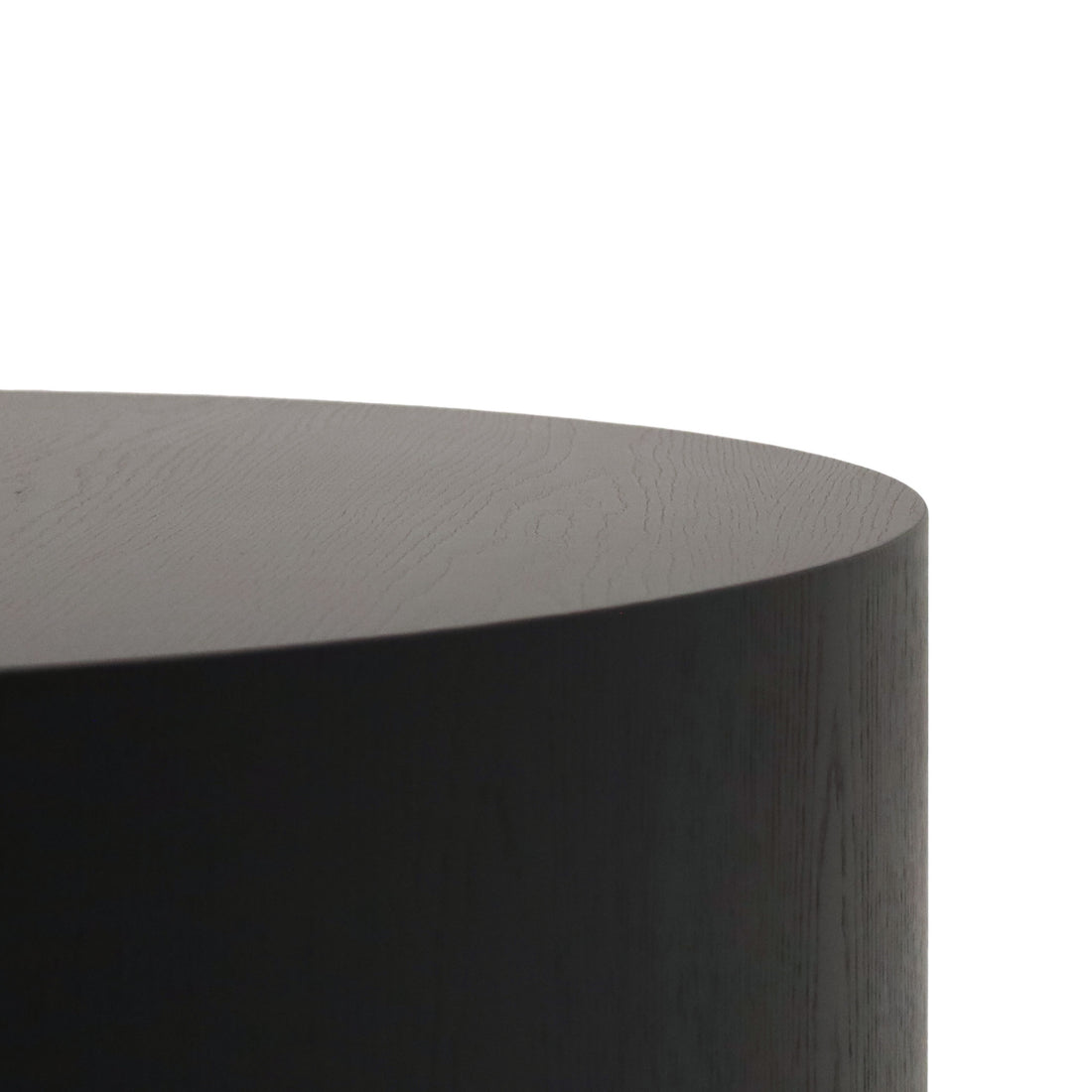 Gros plan de la Table basse circulaire 40 Essence | Onyx de Humble Nature, dotée dune finition lisse fabriquée à partir de matériaux naturels. Le bord et la surface supérieure de cette élégante table se détachent sur un fond blanc.