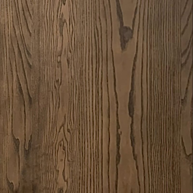 Un gros plan dune surface en bois aux motifs de grain verticaux et aux variations allant du brun clair au brun foncé met en valeur la texture lisse et les détails complexes du placage de chêne rouge brossé, idéal pour la collection Humble Nature Cabinet double fini Pecan | Porte verre.