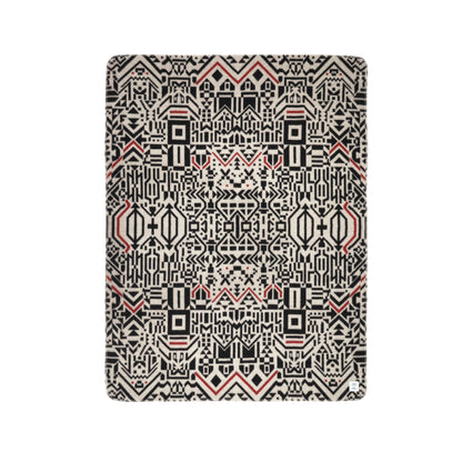 Cet jeté en laine de mérinos Amik rectangulaire par Caroline Monnet présente un motif géométrique complexe en noir, rouge et crème avec des formes symétriques ressemblant à une tapisserie traditionnelle. Il complète votre configuration douillette lorsquil est associé à  des coussins Amik assortis.