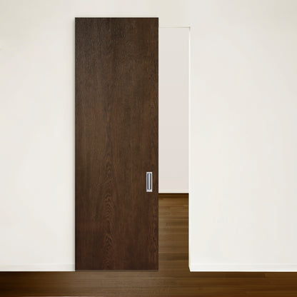 La Porte Pure coulissante en chêne rouge placage brossé sur dosse Pecan de Humble Nature, partiellement ouverte, laisse entrevoir une pièce de couleur claire. Les murs environnants sont blancs et le plancher en bois met en valeur un design moderne, minimaliste mais sophistiqué.